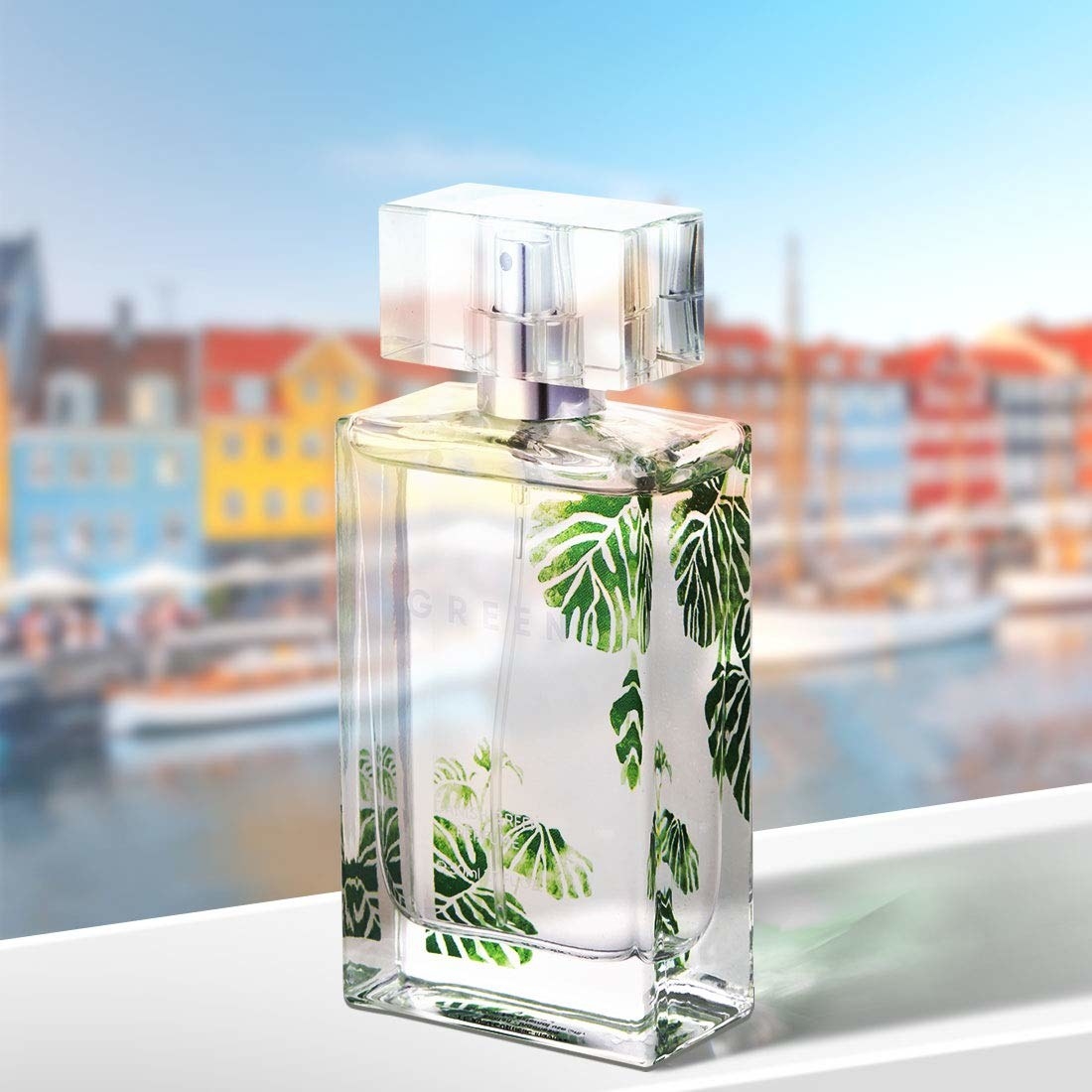 A glass perfume bottle with green leaves printed on it in the scent Danish Green