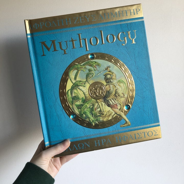 The cover of Mythology; it has a blue background as well as an inner circle containing an artwork of Greek soldiers fighting against monsters