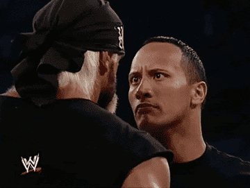 The rock makes intense eye contact with a fellow wrestler