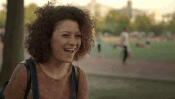 Alia Shawkat from Broad City laughing in a park