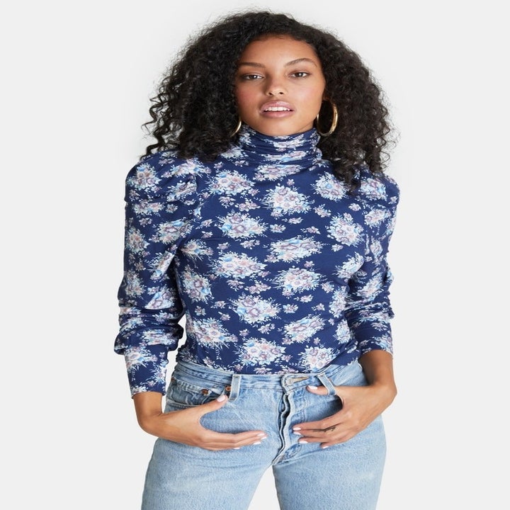 model in navy floral puff sleeve turtleneck