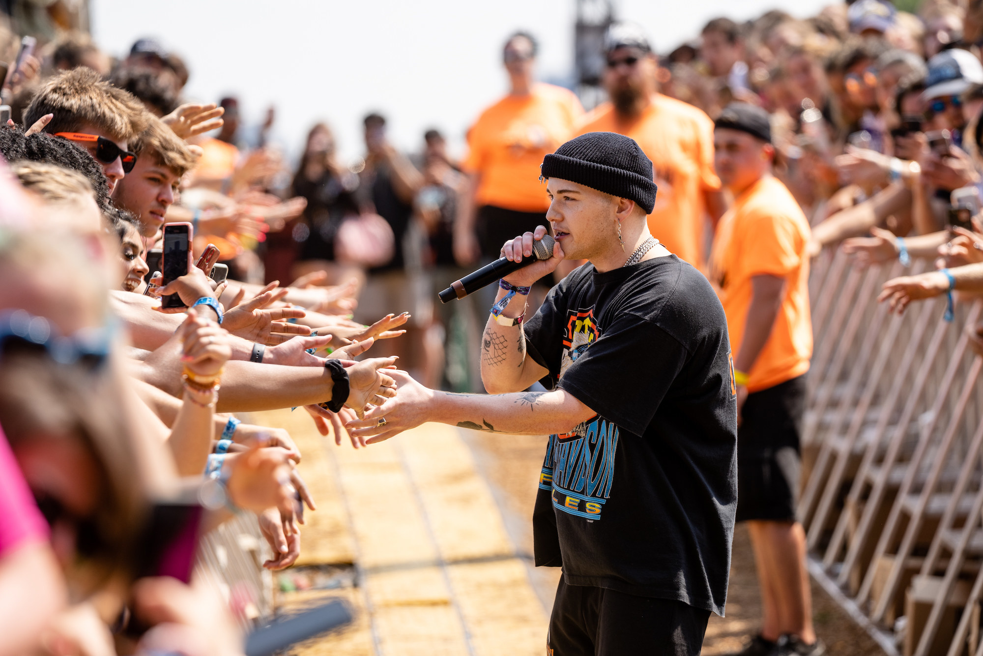 Musician Trevor Daniel shakes hands and sings as he moves through the crowd along the barricades at Lollapalooza.