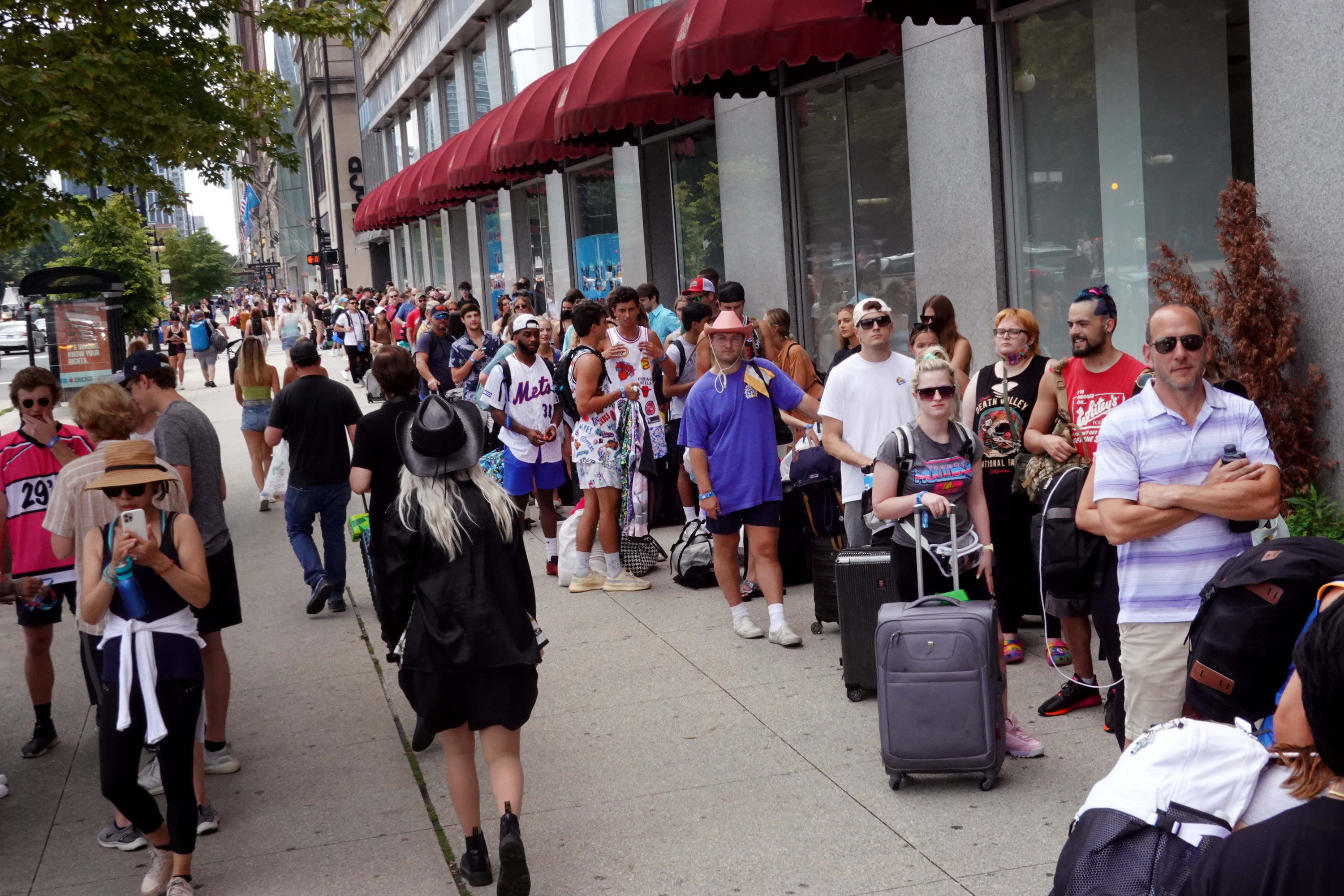 Lollapalooza music festival attendees form a line around a block in Chicago as they prepare to check in to their hotel.