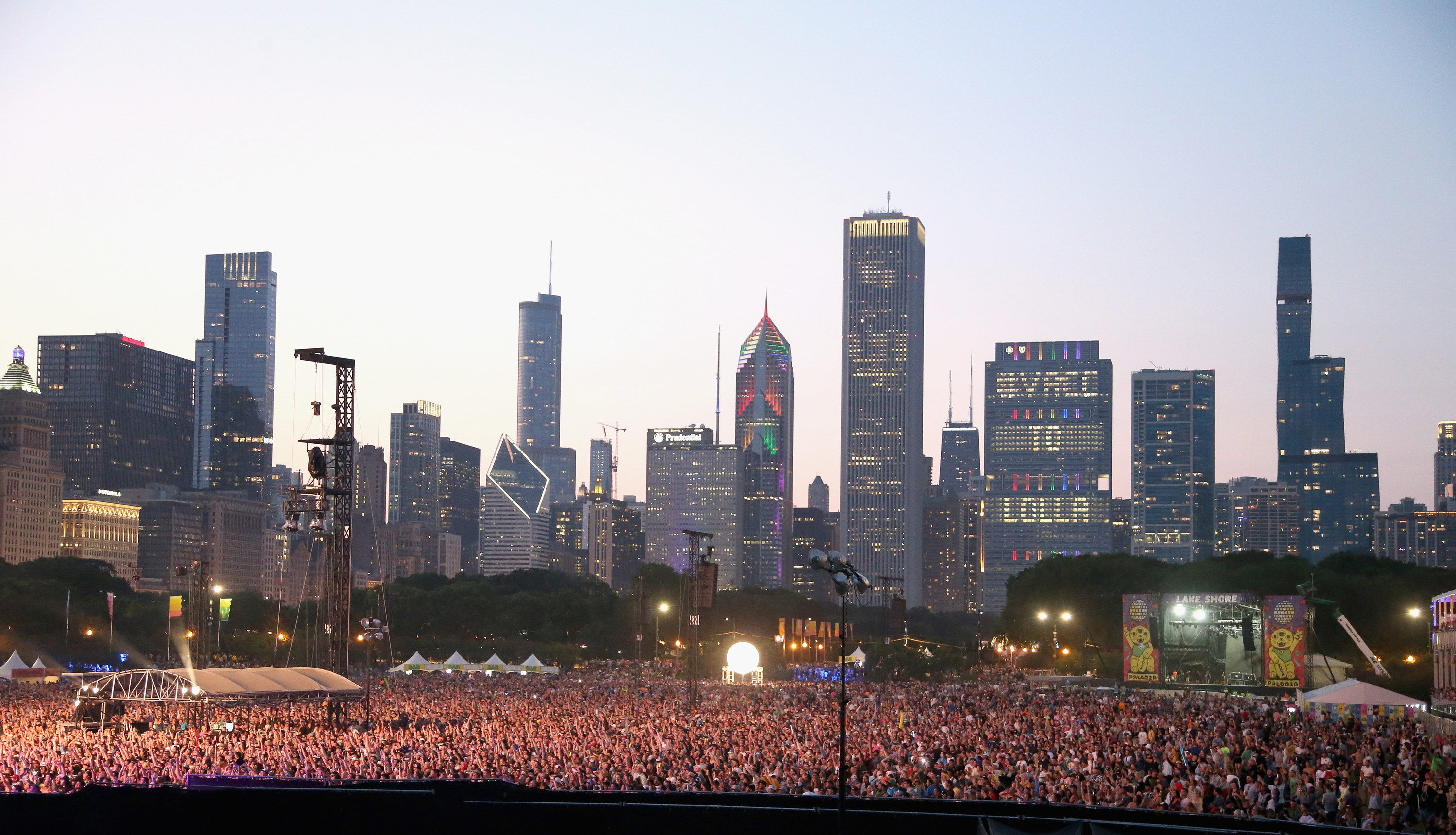 The Chicago skyline lights up with the words &quot;Vacc to Lolla&quot; behind a crowd of evening festival attendees at Lollapalooza music festival.