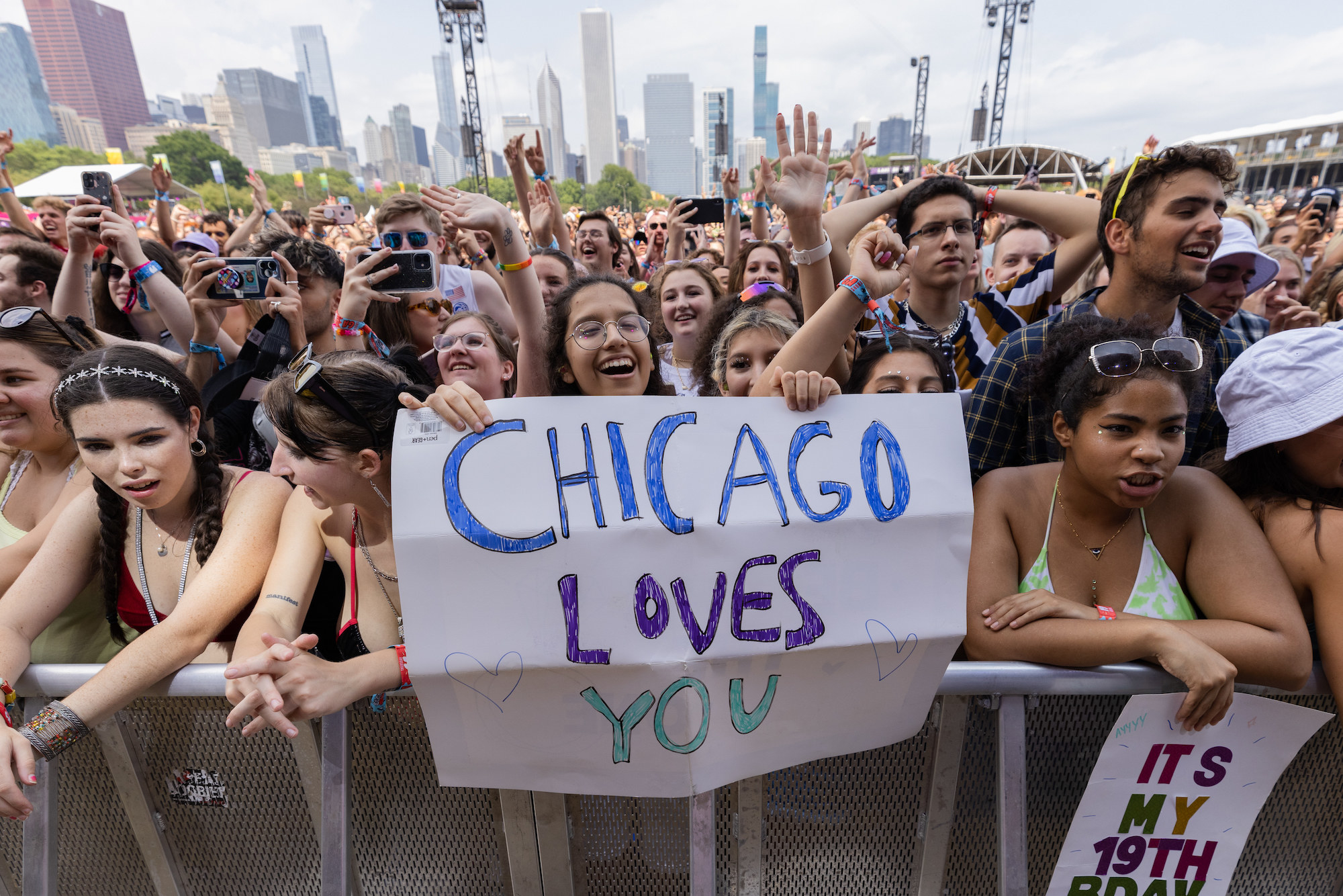 Festival attendees hold a &quot;Chicago Loves You&quot; sign as they await a performance at Lollapalooza.