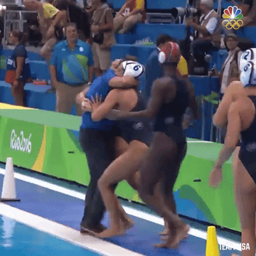Members of Team USA Water Polo team hug one another before jumping into the pool