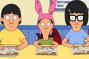 Gene, Louise, and Tina Belcher sit wiping menus at the counter of their burger restaurant