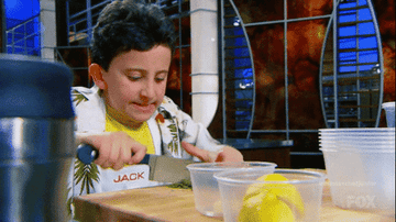 A MasterChef Junior contestant animatedly chopping herbs