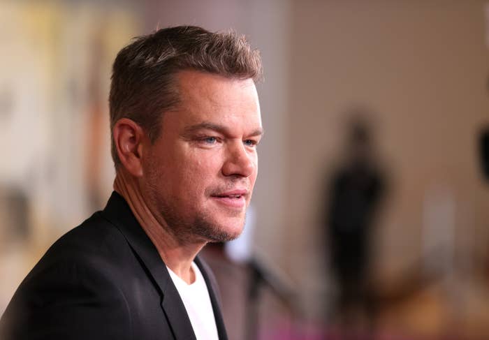 Closeup photo of Matt Damon in a black blazer and white shirt looking off-camera