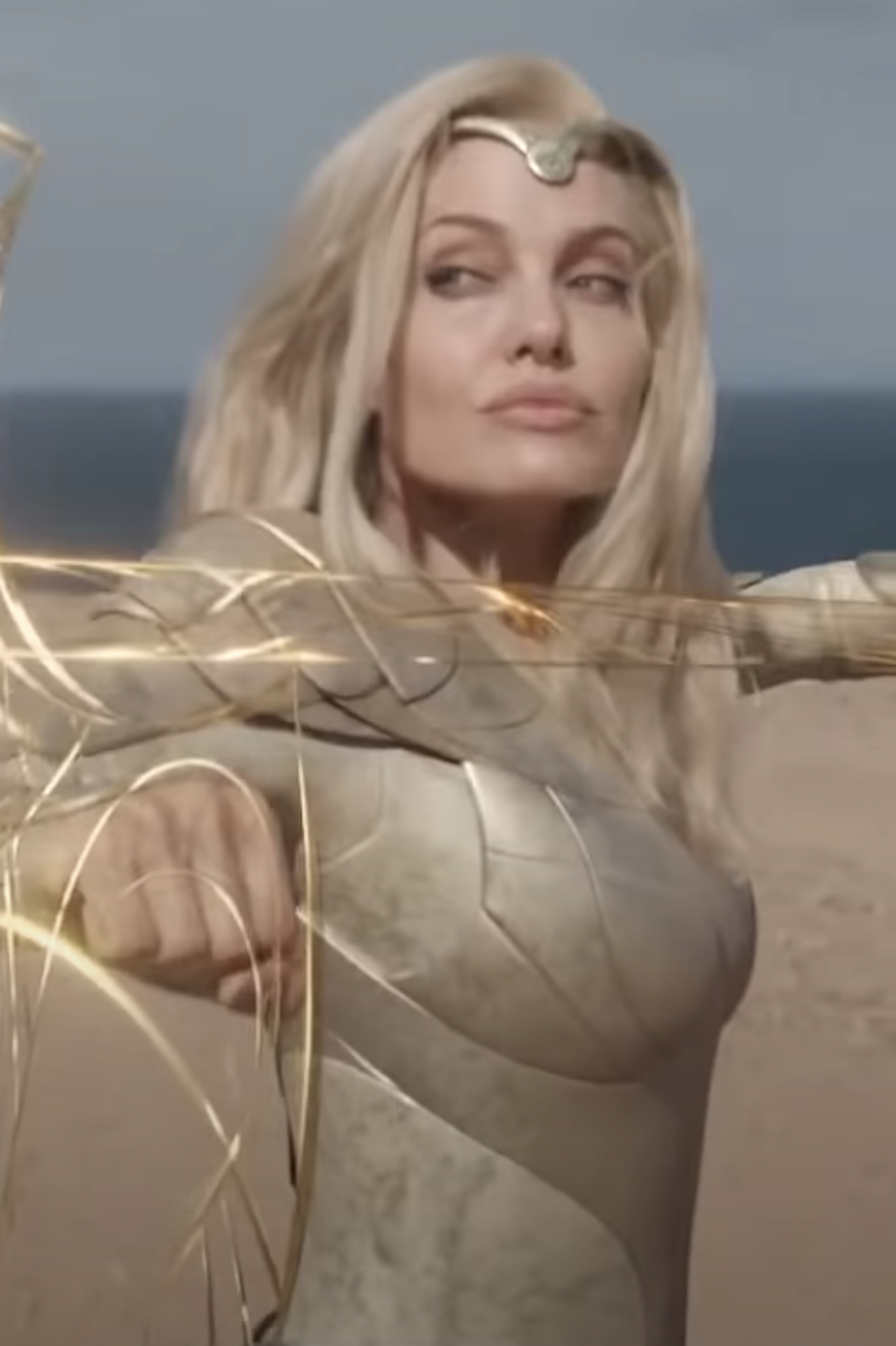 Angelina Jolie with long, light hair, fighting with a golden weapon