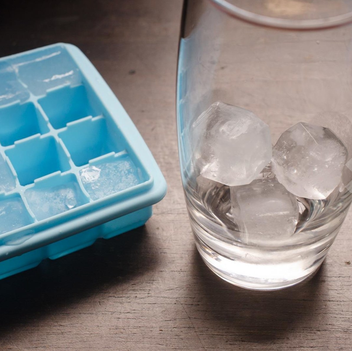 one of the silicone ice cube trays in blue with a reviewer&#x27;s glass