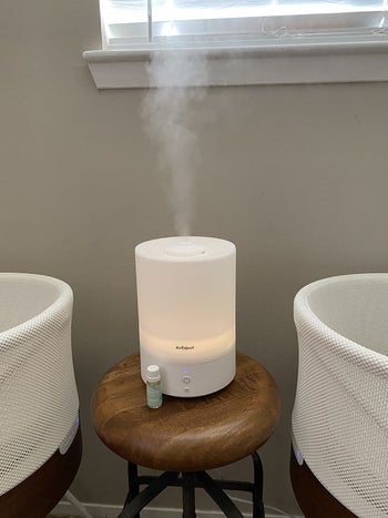 Reviewer's photo showing a bottle of vapor drops sitting next to a diffuser and a crib