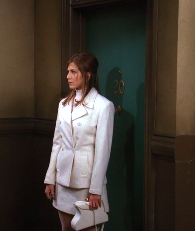 Rachel wearing a skirt, a knit top, and a matching coat