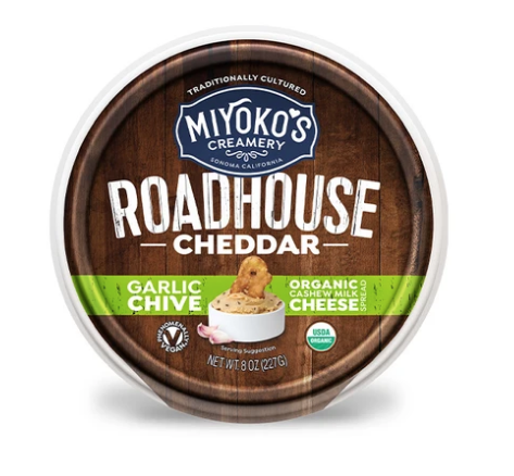 A circular can of cheddar with a wooden pattern on it