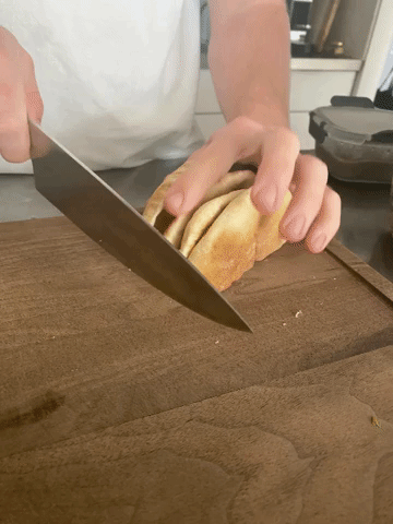 gif of the writer using the knife and cutting board to slice pita bread