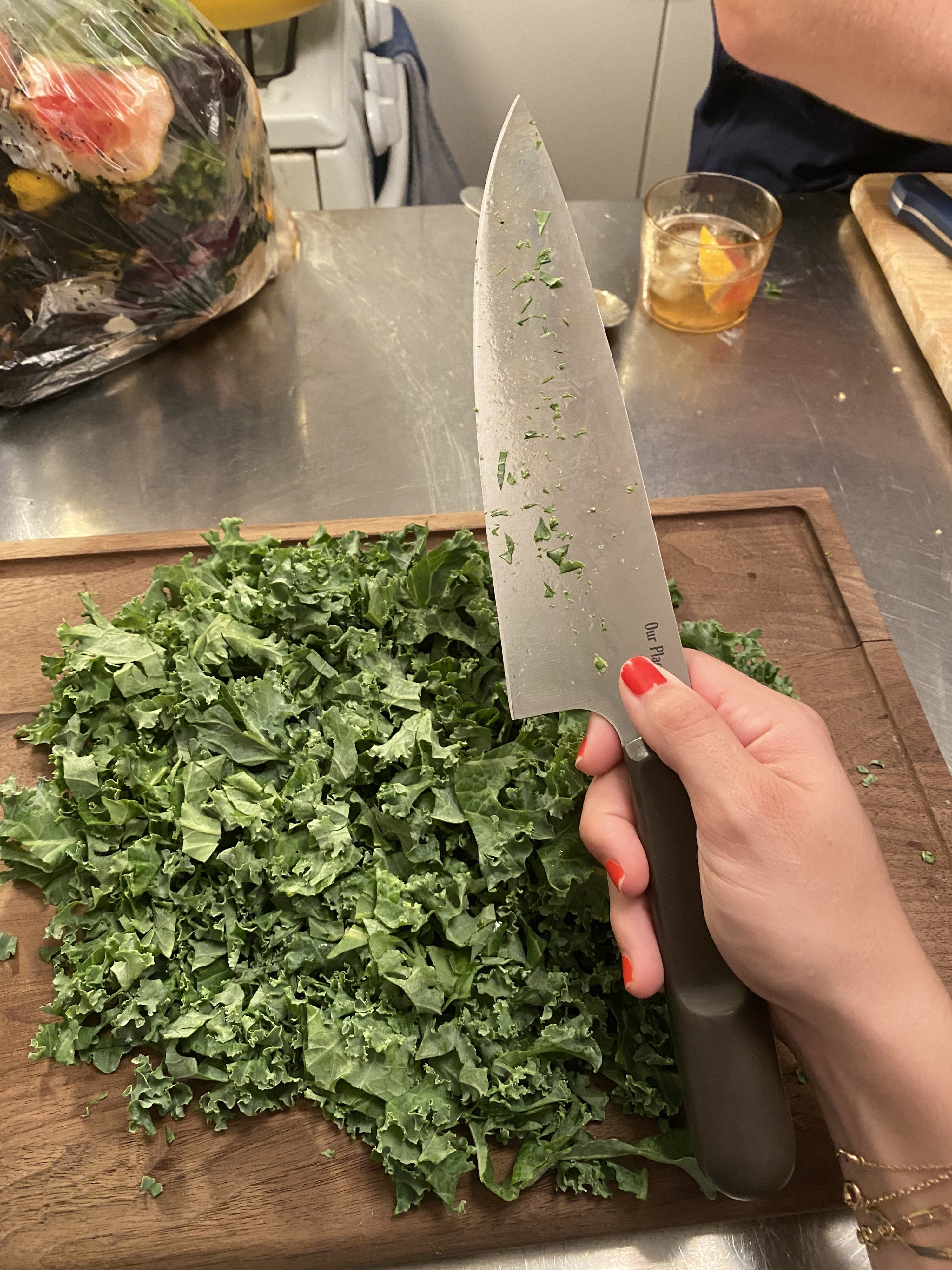 the knife and cutting board being used to chop kale