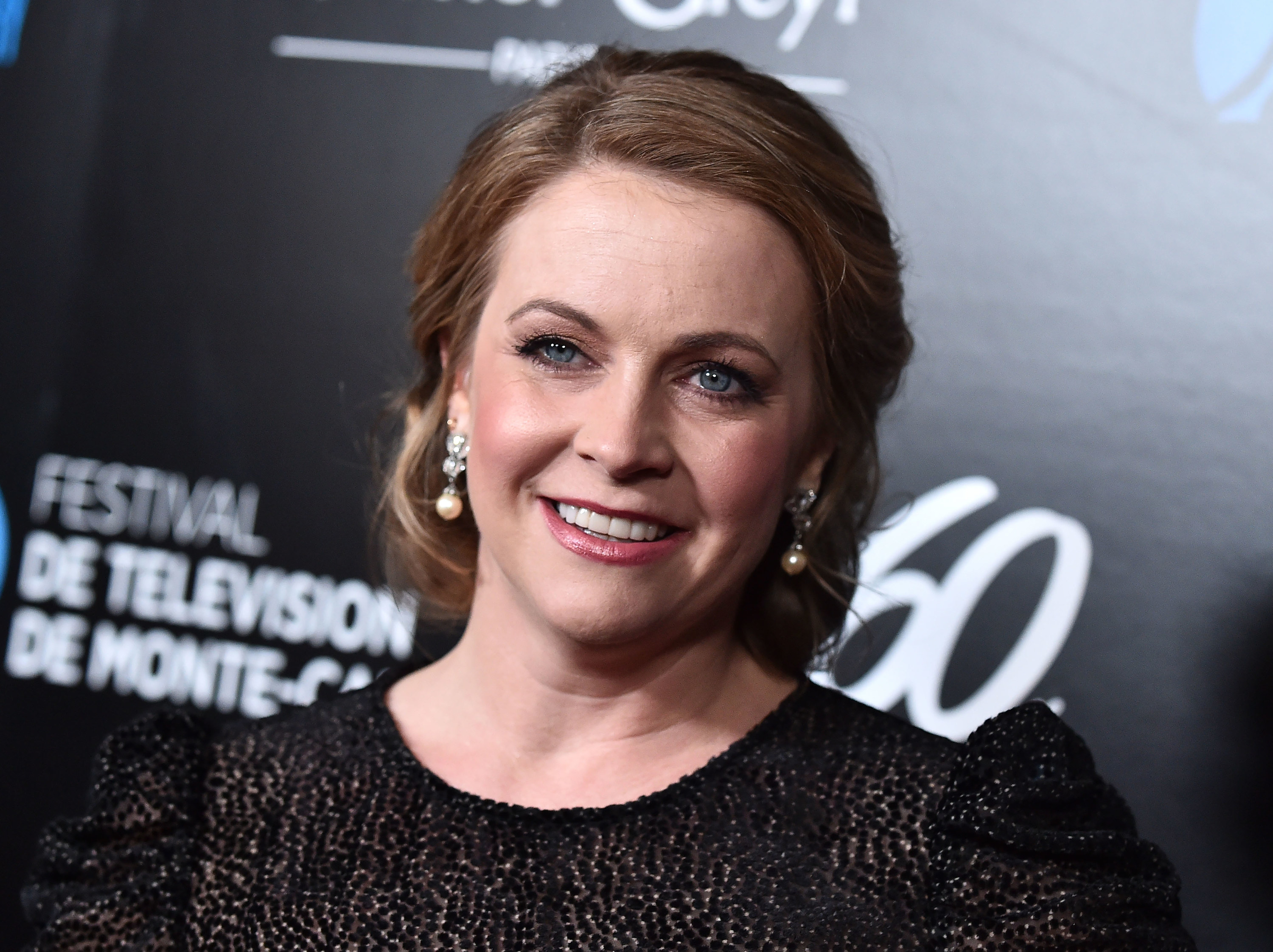 Closeup photo of Melissa Joan Hart smiling at something off-camera