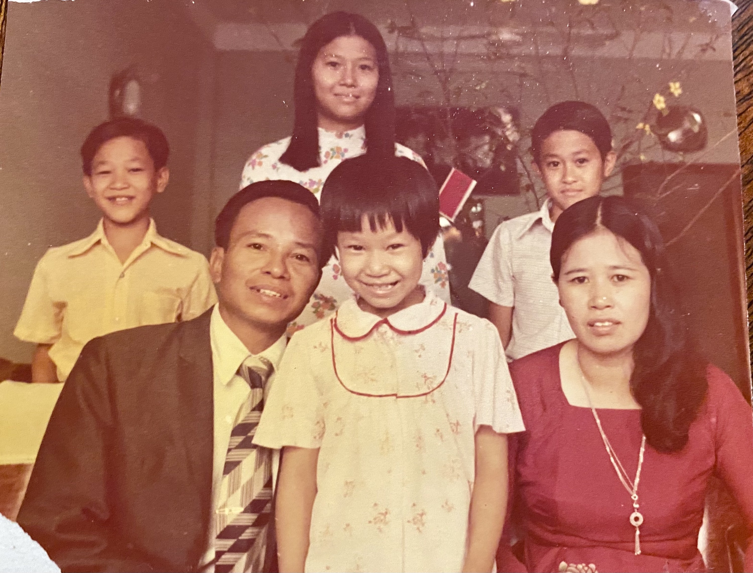 Four children with their parents smile at the camera