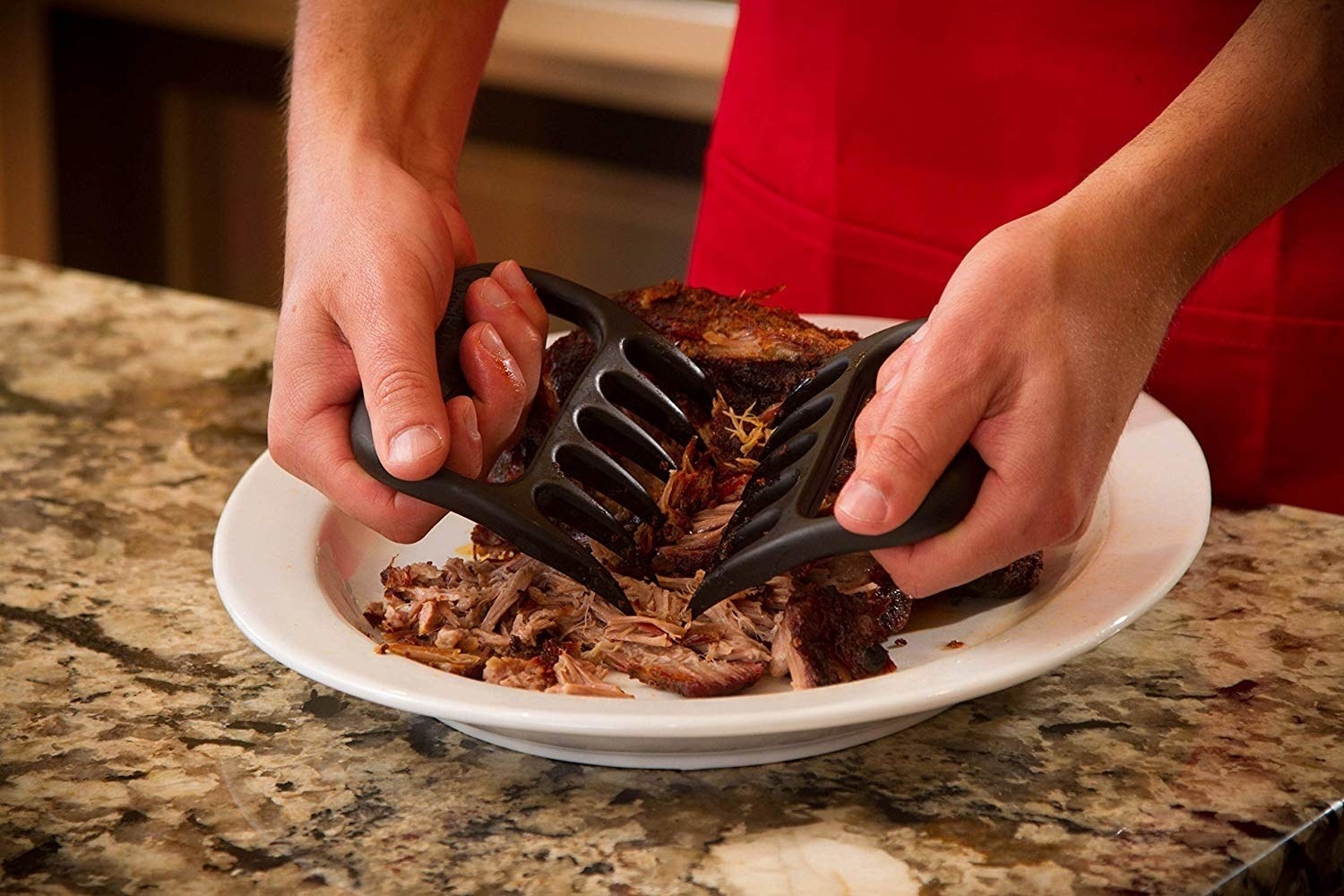 a model using the black shredder claws to shred meat