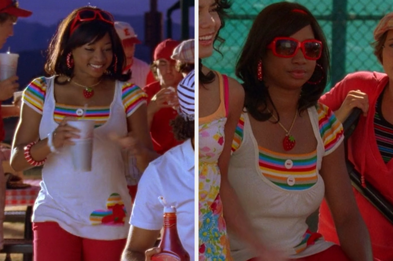 Monique wearing a rainbow striped short sleeve shirt under a white tank top, red pants, a strawberry necklace, red sunglasses, polka dot hoop earrings, and a red striped bracelet