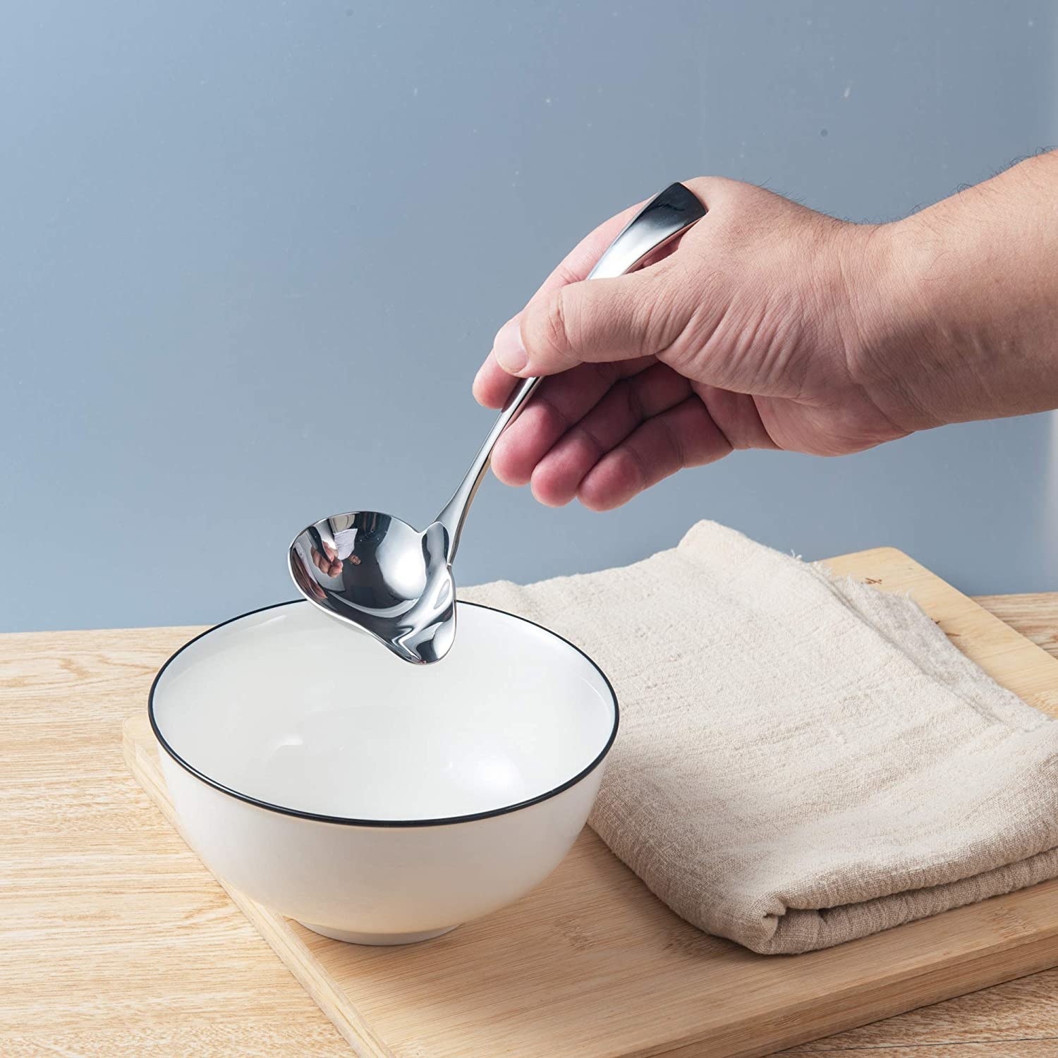 A person holding the spoon over a bowl