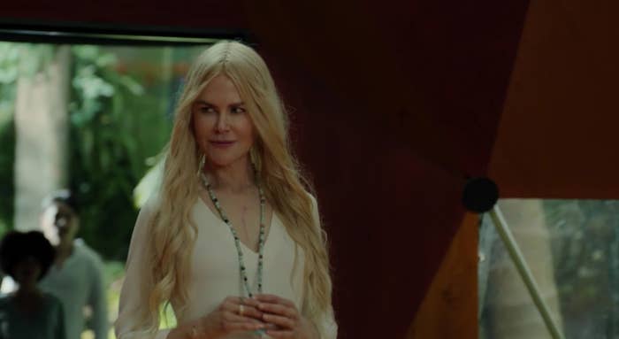 nicole kidman looking to the right of her while holding her necklace