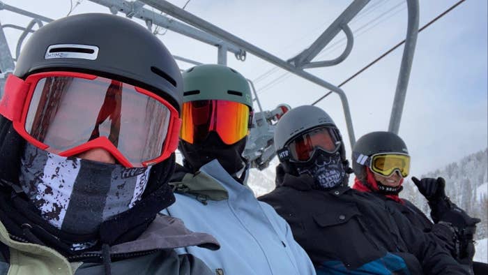 Riding on the ski lift with friends in my blue snowboarding gear. 