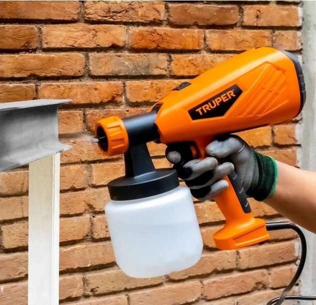 Foto de persona utilizando pistola de pintura eléctrica