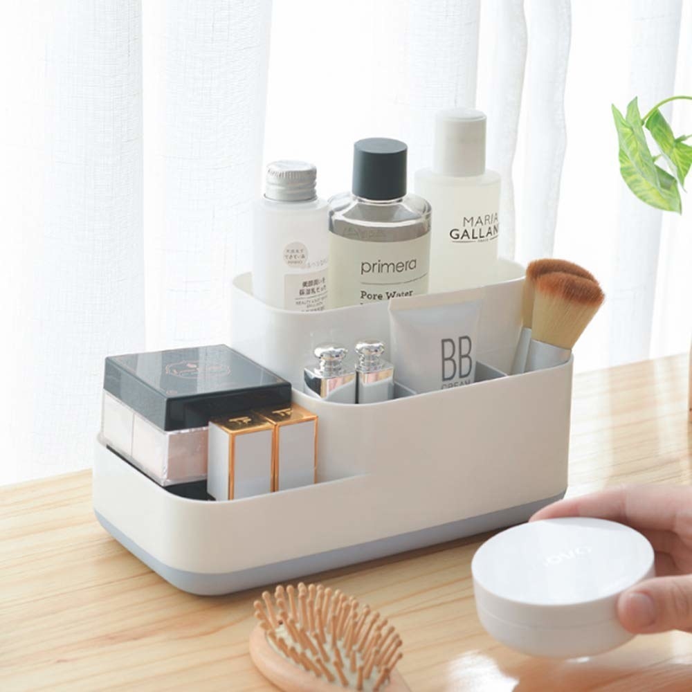 A 5-compartment organiser with creams and makeup products inside it
