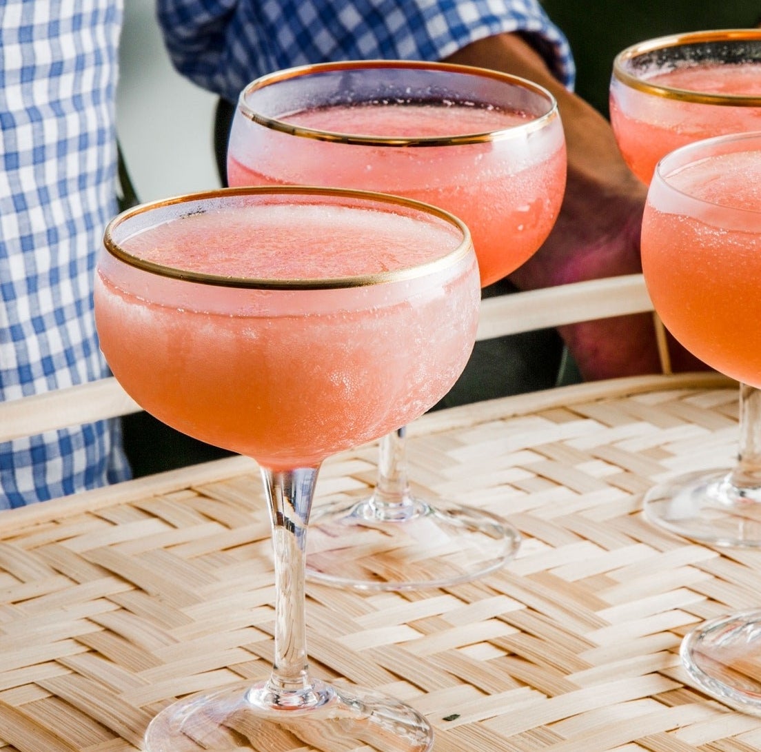 A tray holding four frosty glasses of frozen rosé