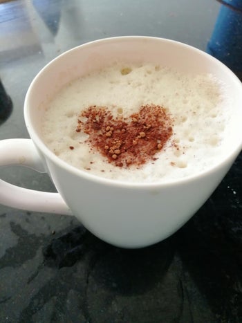 a reviewer's coffee with foam on top