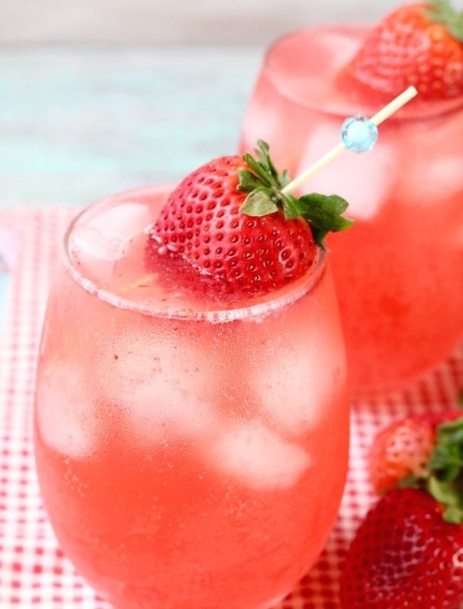 Iced strawberry wine punch in a glass with a strawberry garnish