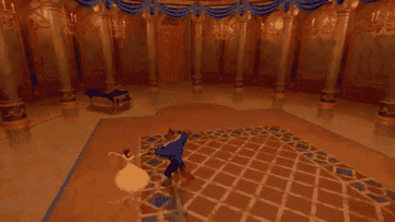 Belle and the Beast slow dance in a magnificent ballroom as the camera pans around them.