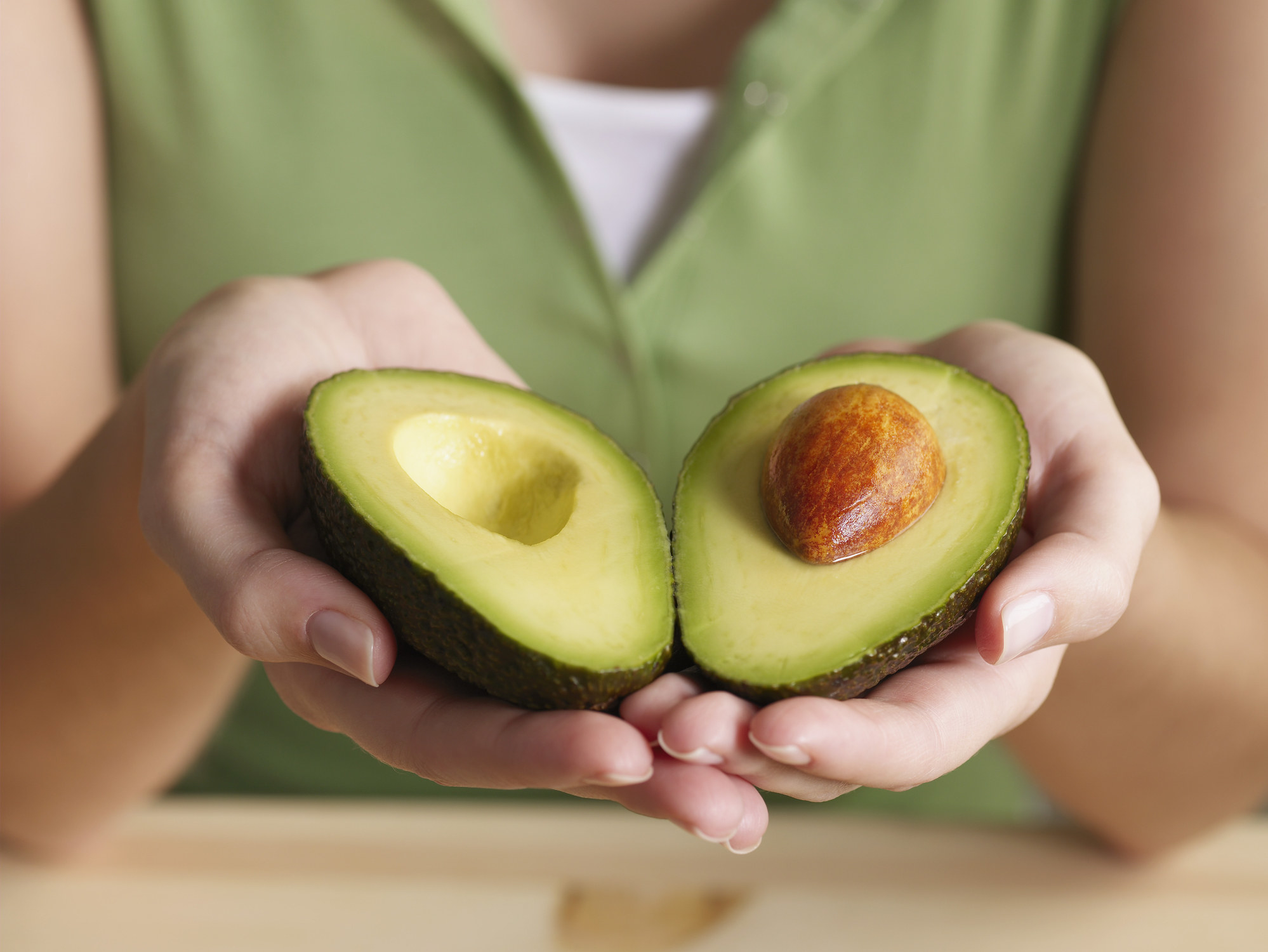 a person holding an avocado