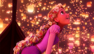 Rapunzel leans over in a canoe, watching thousands of lit lanterns fly into the sky.