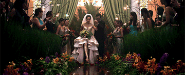 An elegant bride steps barefoot into a river of water and flowers leading her down the aisle.