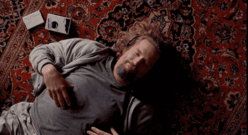 The Dude lays on his rug listening to his walkman