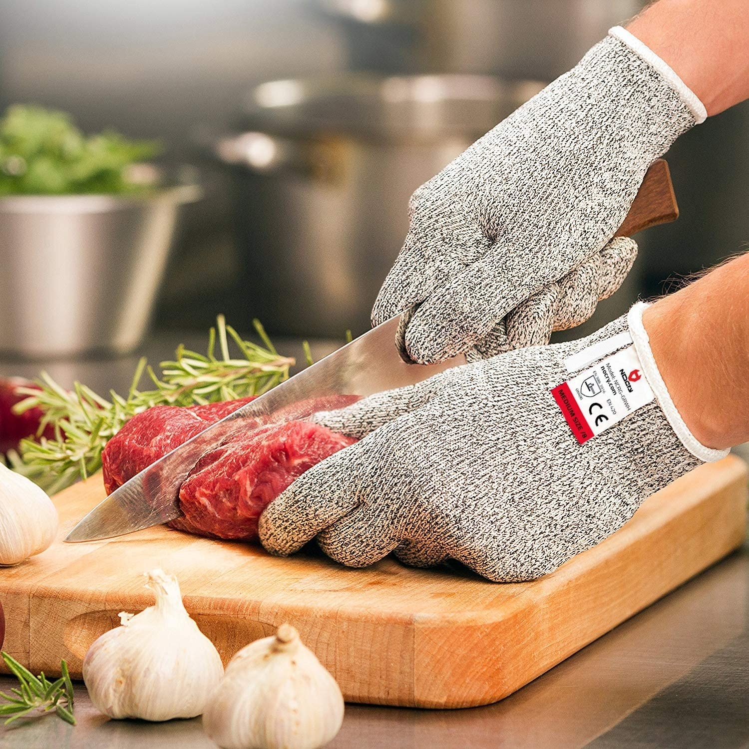 A person wearing the gloves while cutting a piece of meat