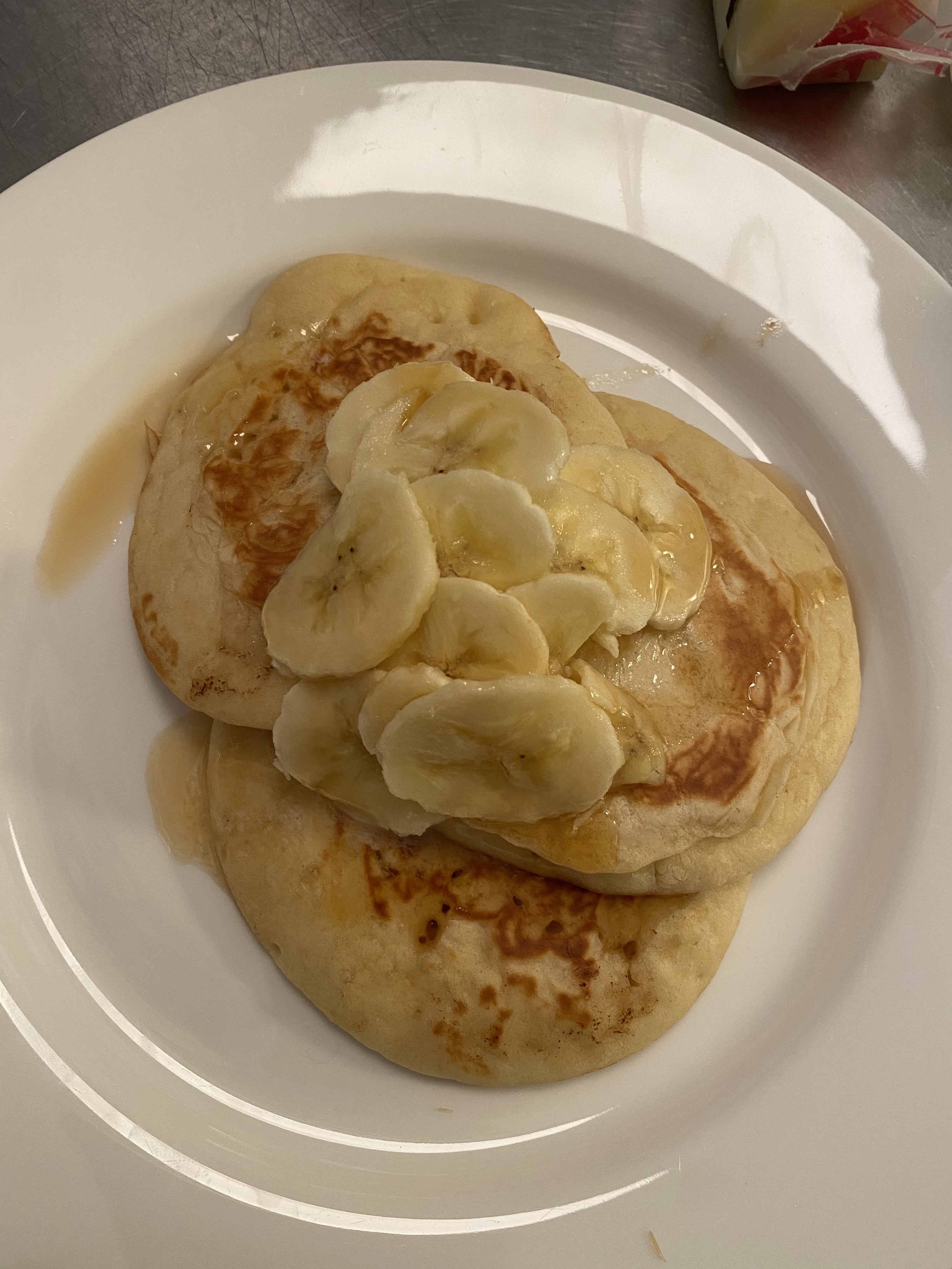 the pancakes with banana slices on a white plate