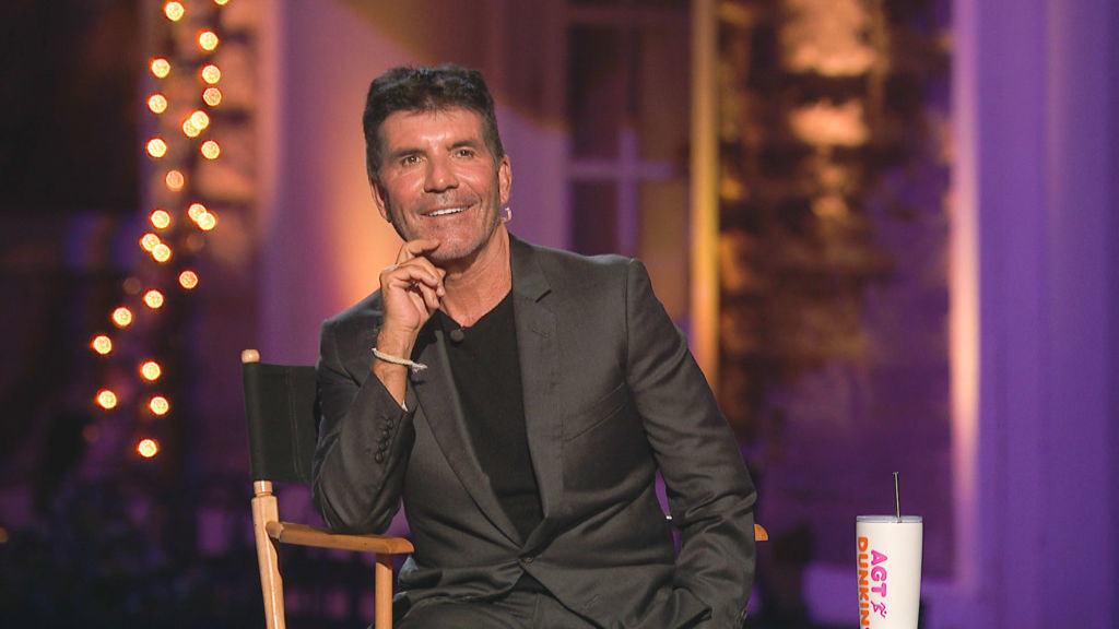 Simon Cowell smiles in his director&#x27;s chair