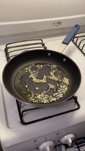 gif of garlic sizzling in a pan with oil