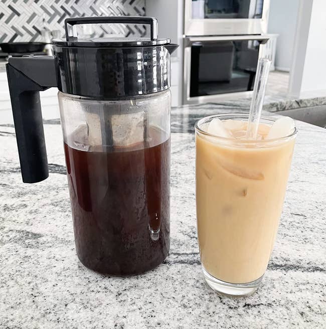Pitcher of cold brew next to a cup of iced coffee