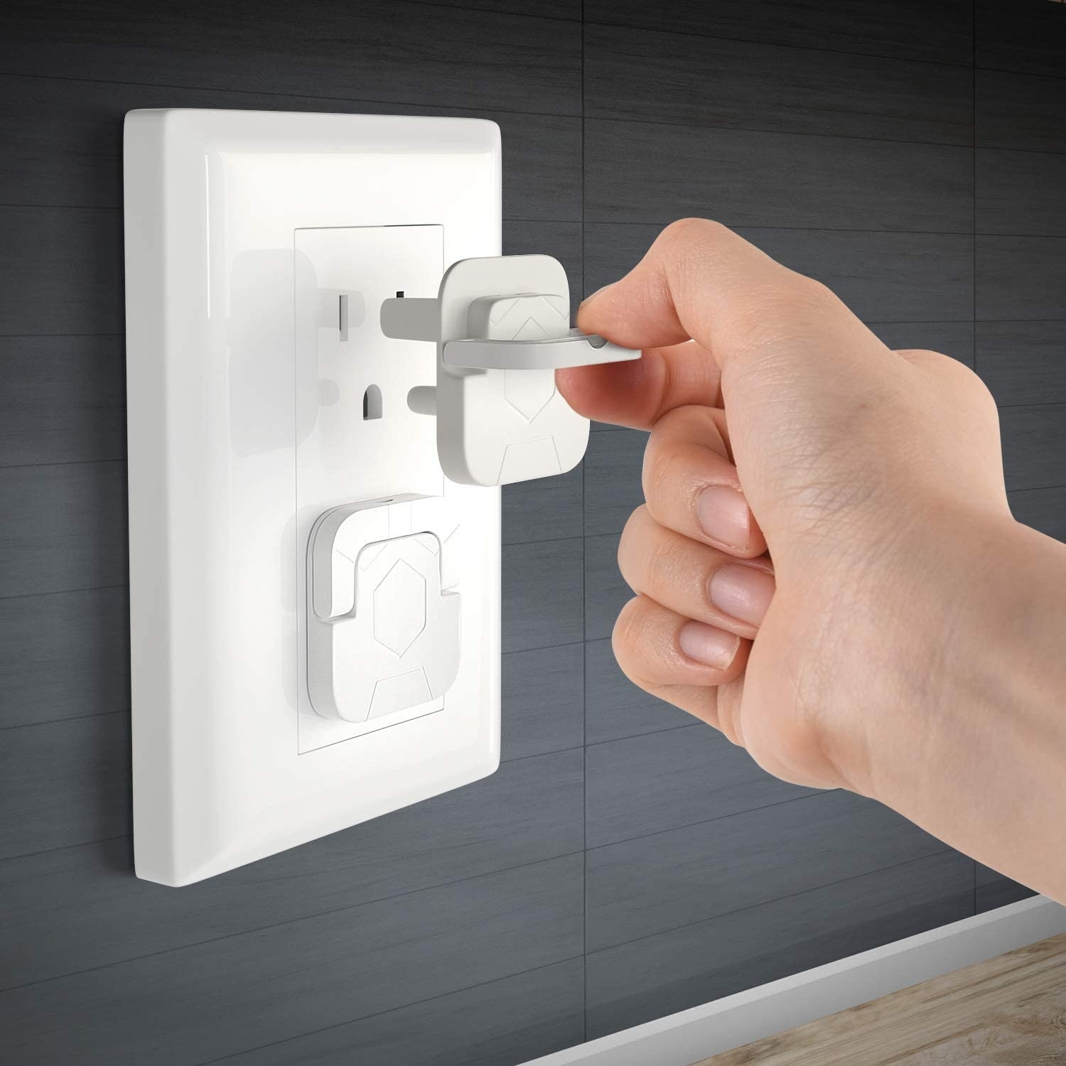 A person putting an outlet cover into a socket