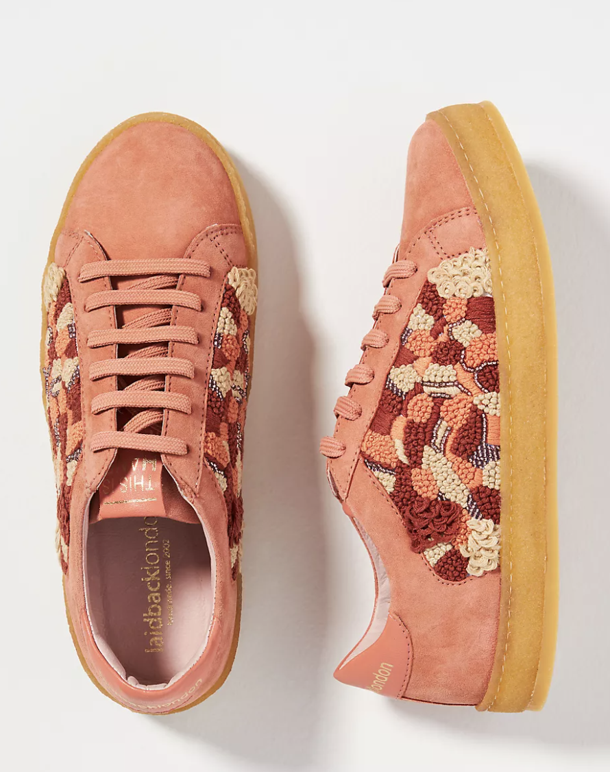 orange sneakers with pink, orange, tan, and beading detailed embroider on the side and a mustard yellow bottom