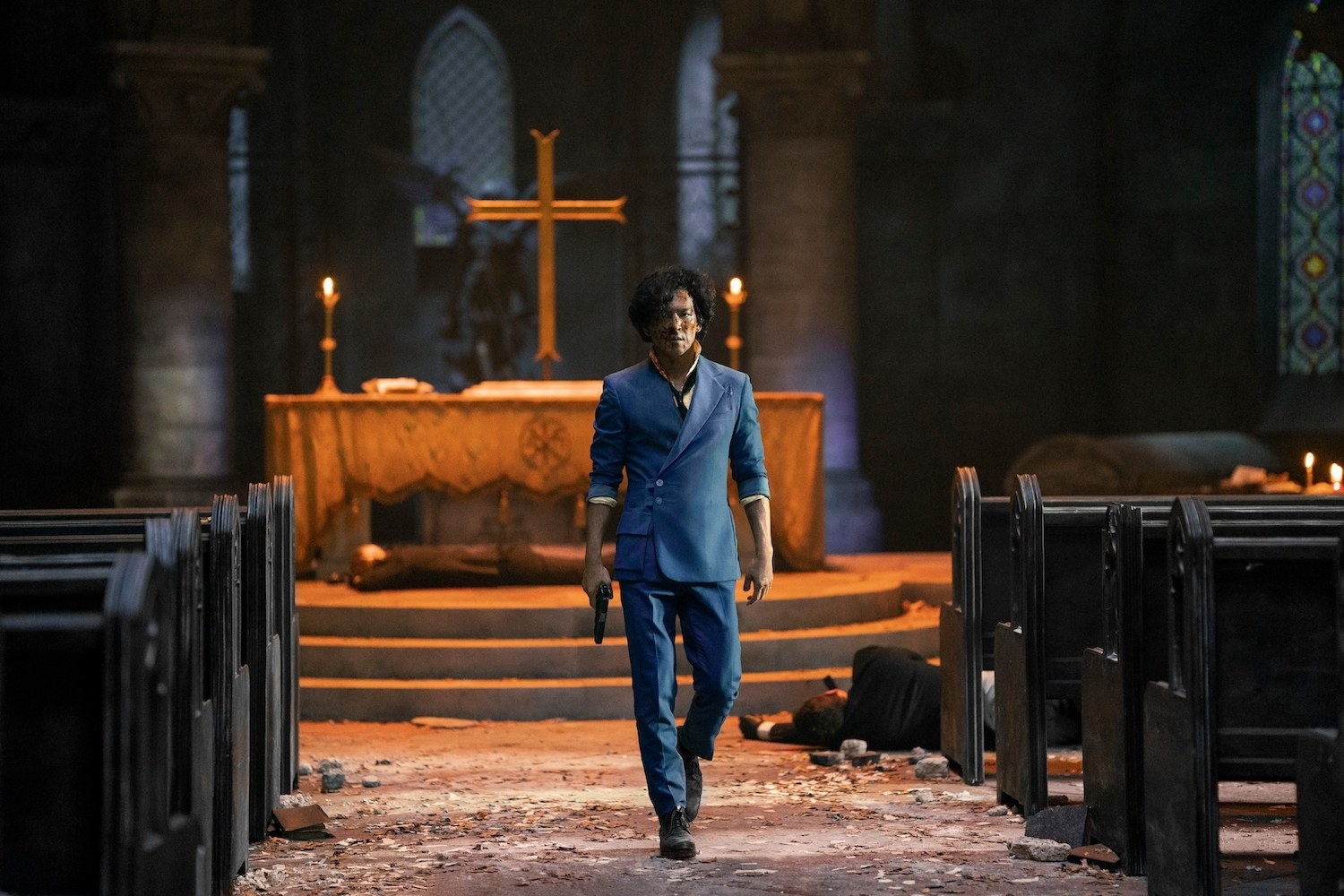 Cho as a battered and bloody Spike walking through a church with rubble and bodies around him