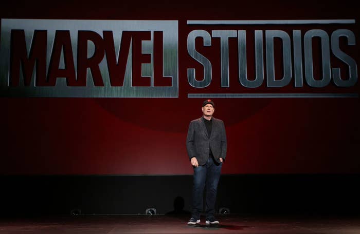 Kevin Feige standing on stage in front of the Marvel Studios logo
