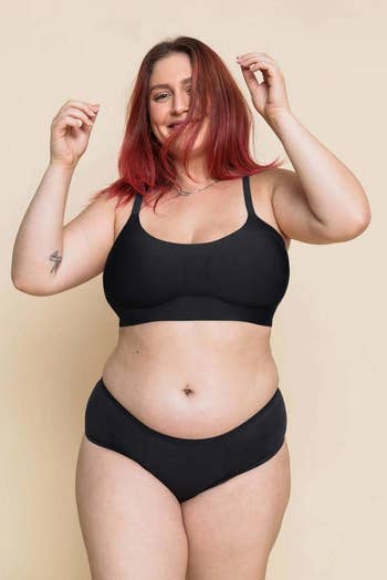 a model wearing the bra in black with a matching pair of underwear 