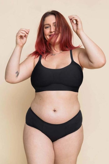 a model wearing the bra in black with a matching pair of underwear 