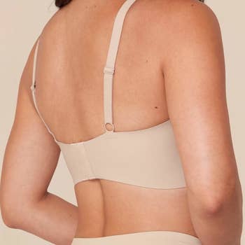 the back view of a model wearing the bra in tan 