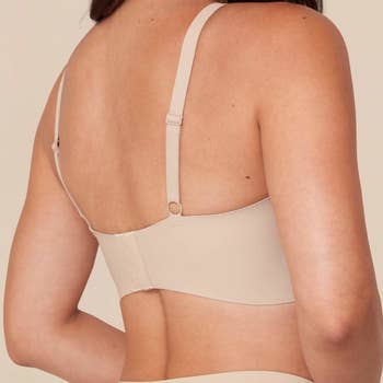 the back view of a model wearing the bra in tan 